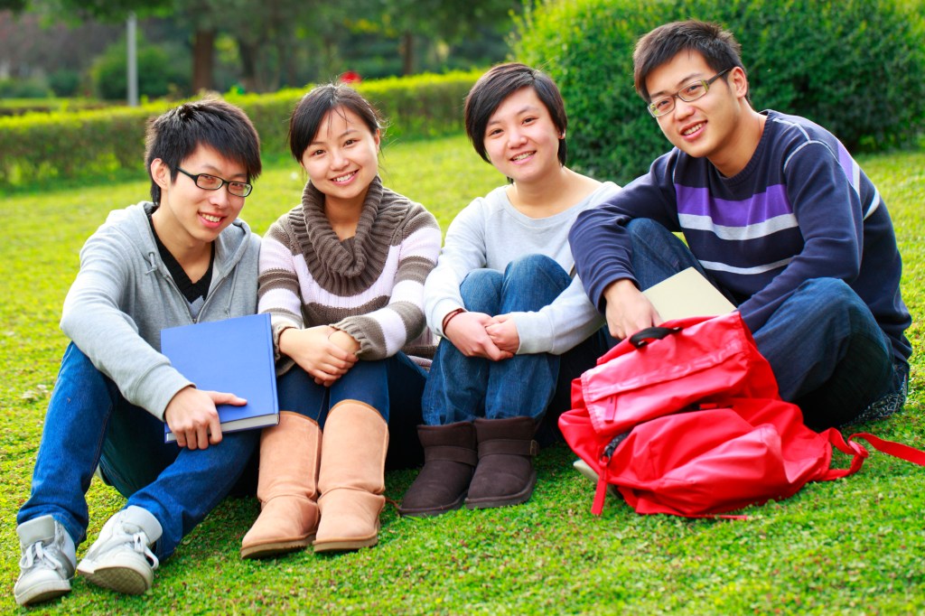 four young asian college students sitting in the campus