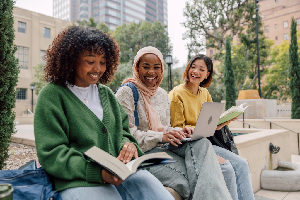 Three teenage student friends studying outdoors in the University campus